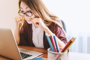 Žena kreira online kurs uz laptop u organizovanom digitalnom radnom prostoru
